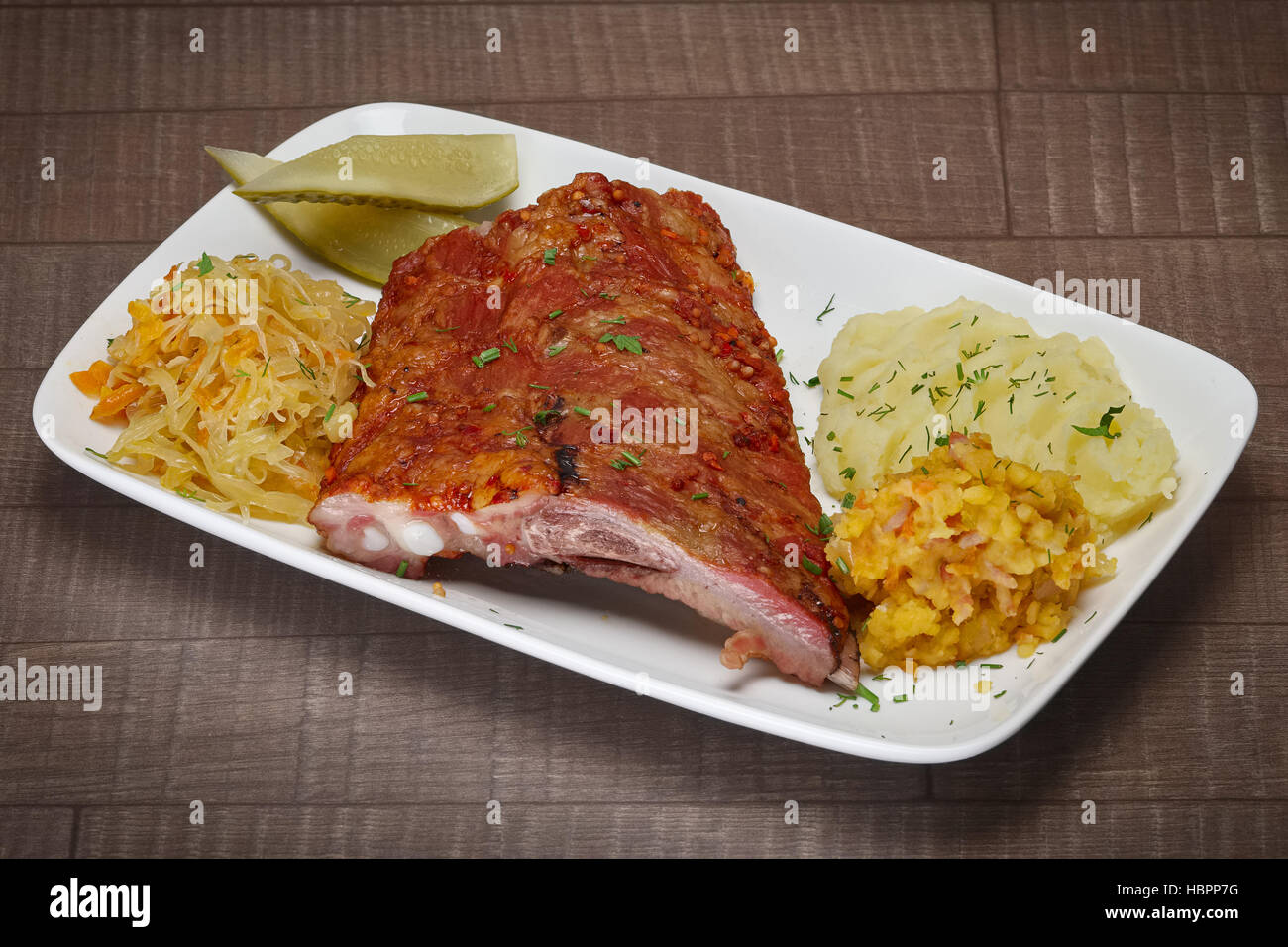 Medium grilled beef ribs served with mashed potatoes, cucumber and cabbage Stock Photo