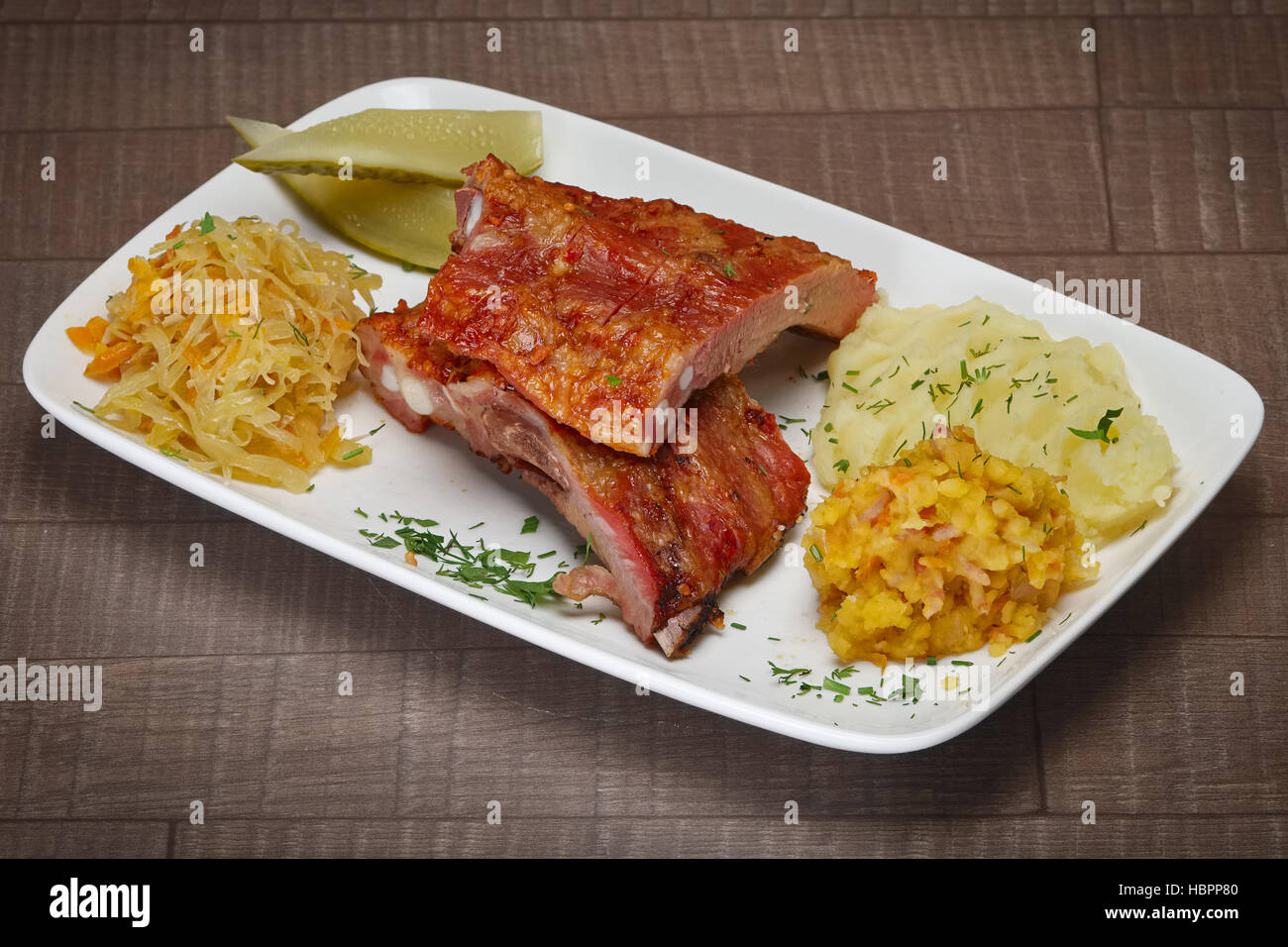Medium grilled beef ribs served with mashed potato, cucumber and cabbage Stock Photo