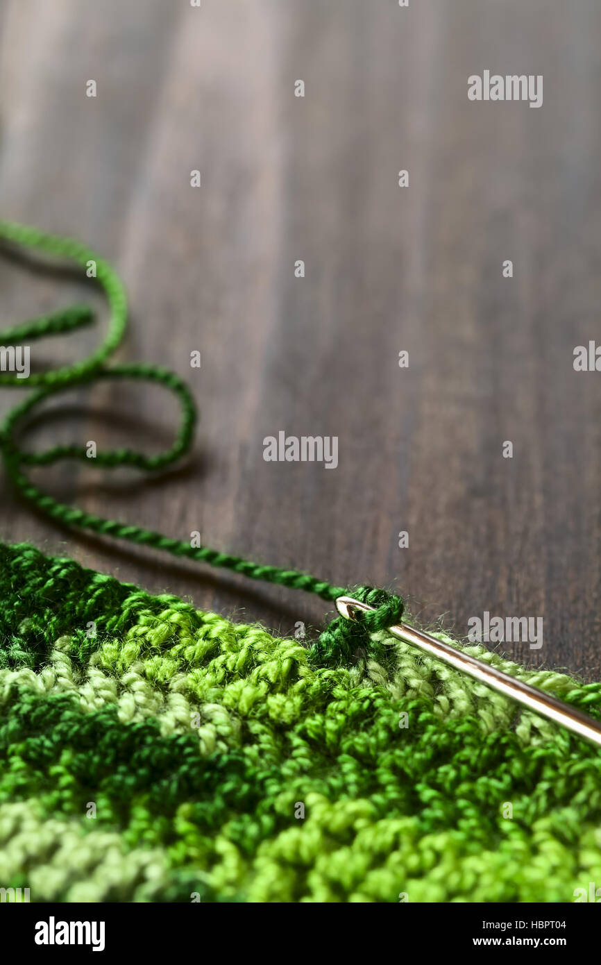 Crochet handicraft, making a place mat out of green yarn with a pattern