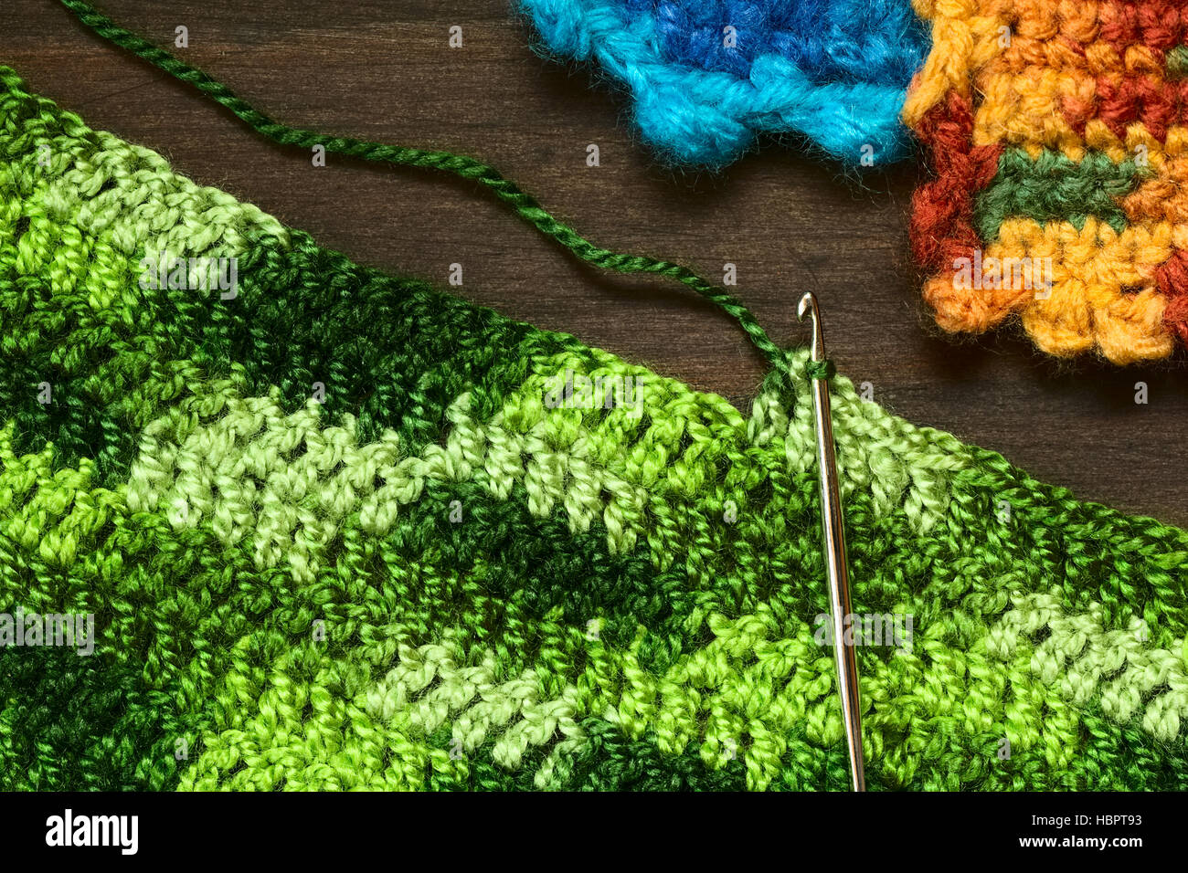 Crochet handicraft, making a place mat out of green yarn with a pattern