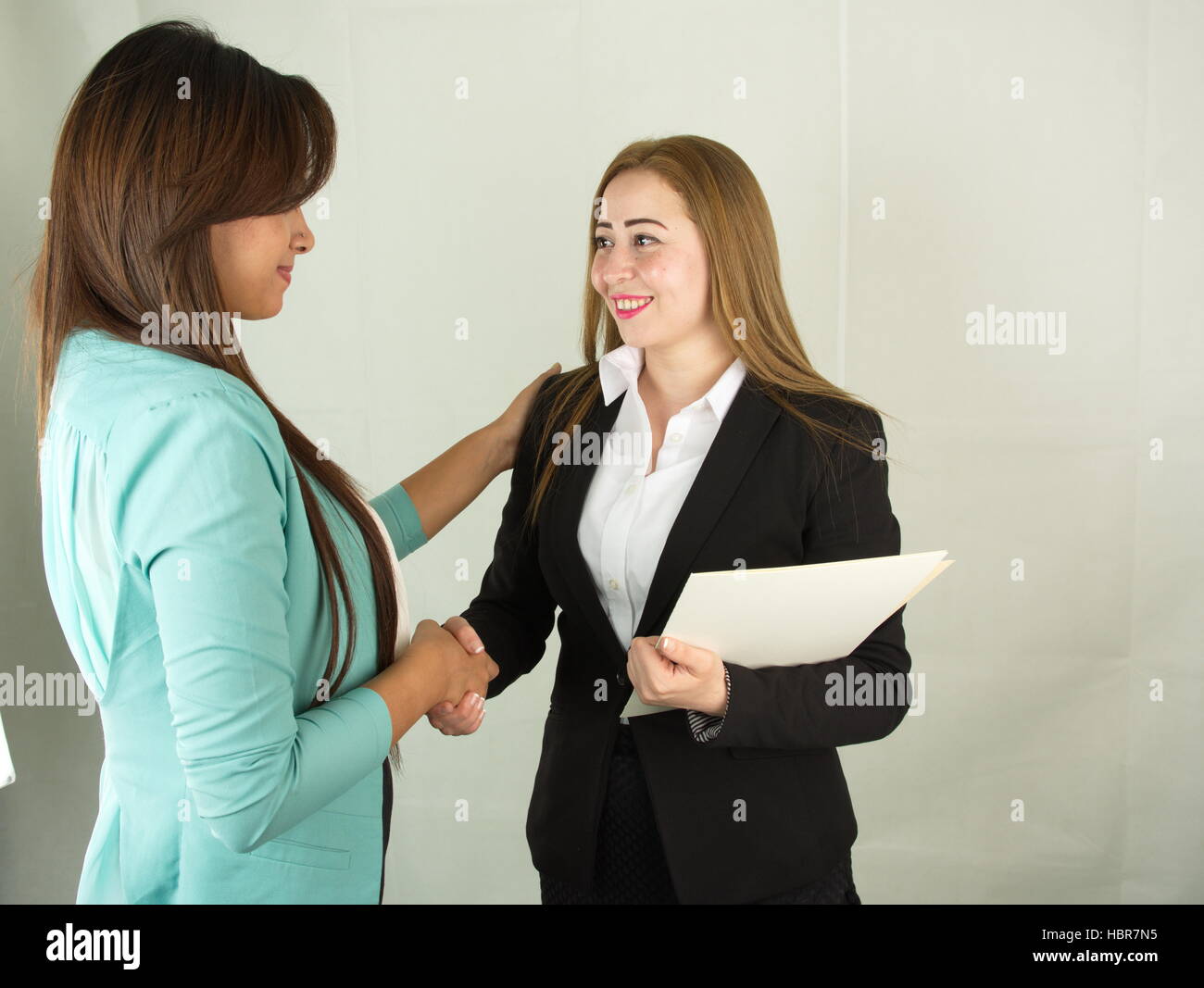 Two Egyptian business women shaking hands at boardroom Stock Photo Alamy