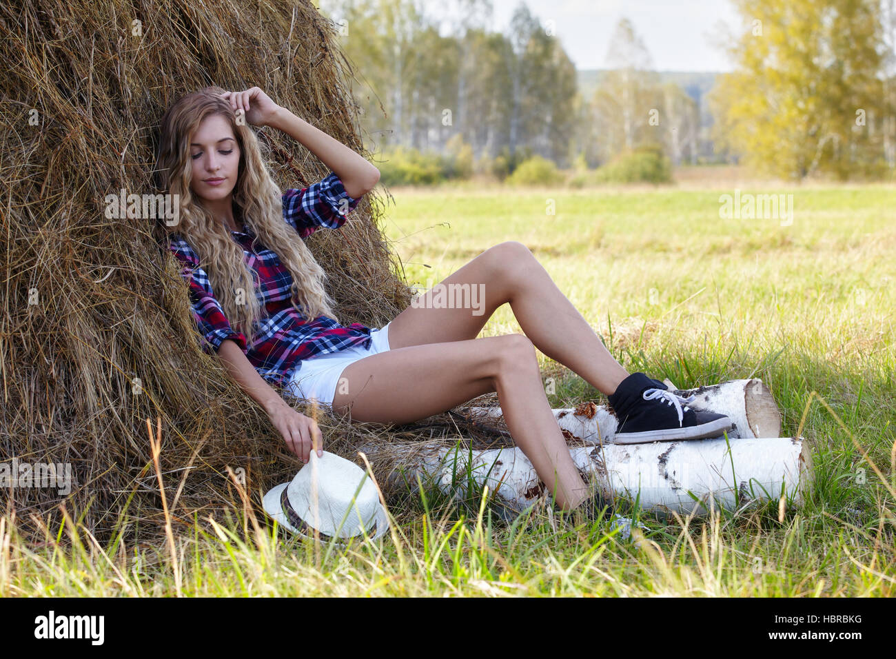 Young blonde country girl near haystacks Stock Photo
