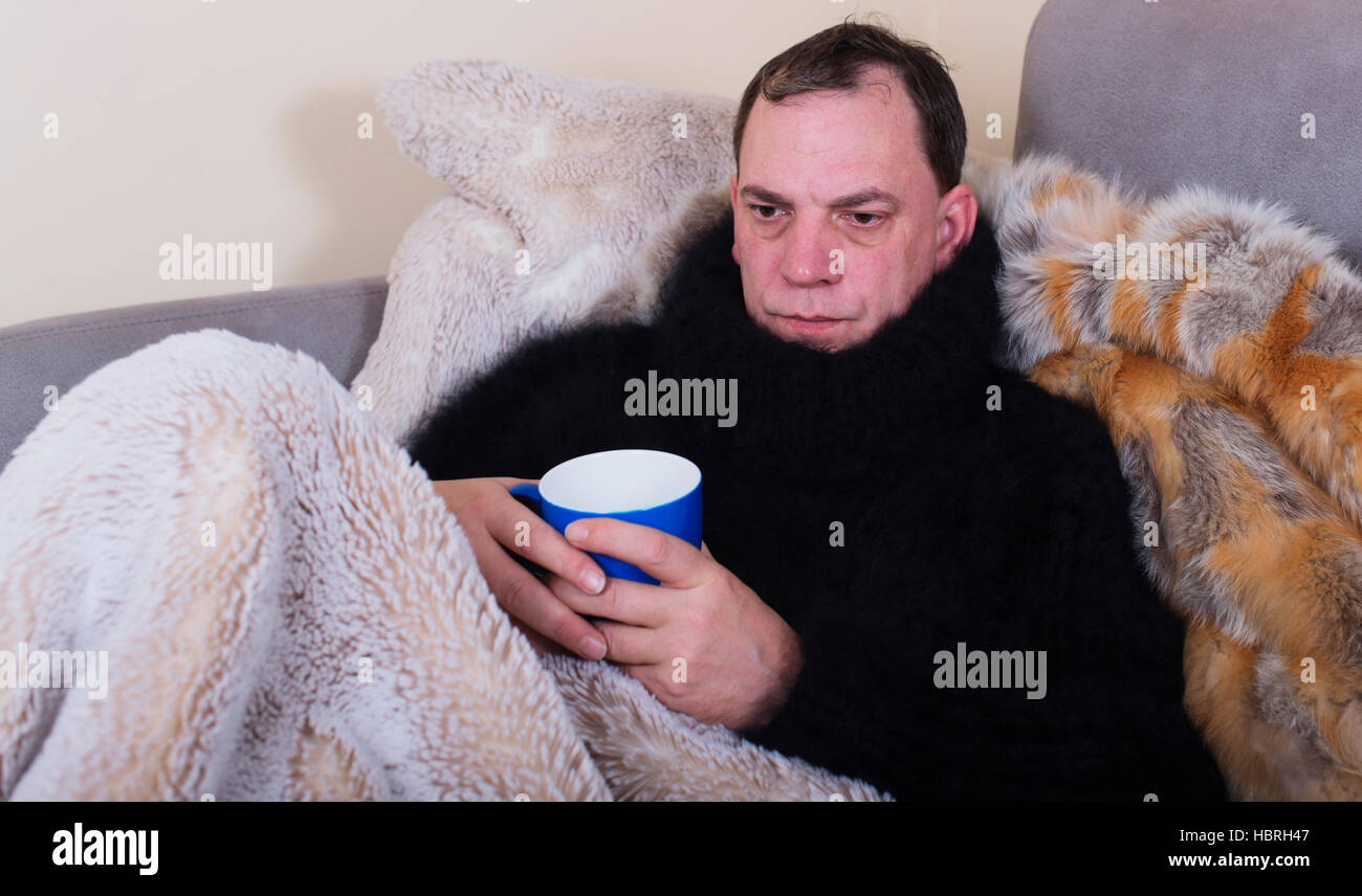man is sick and drinks tea Stock Photo
