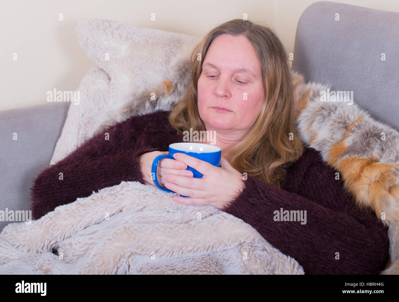 Woman is sick and drinks tea Stock Photo