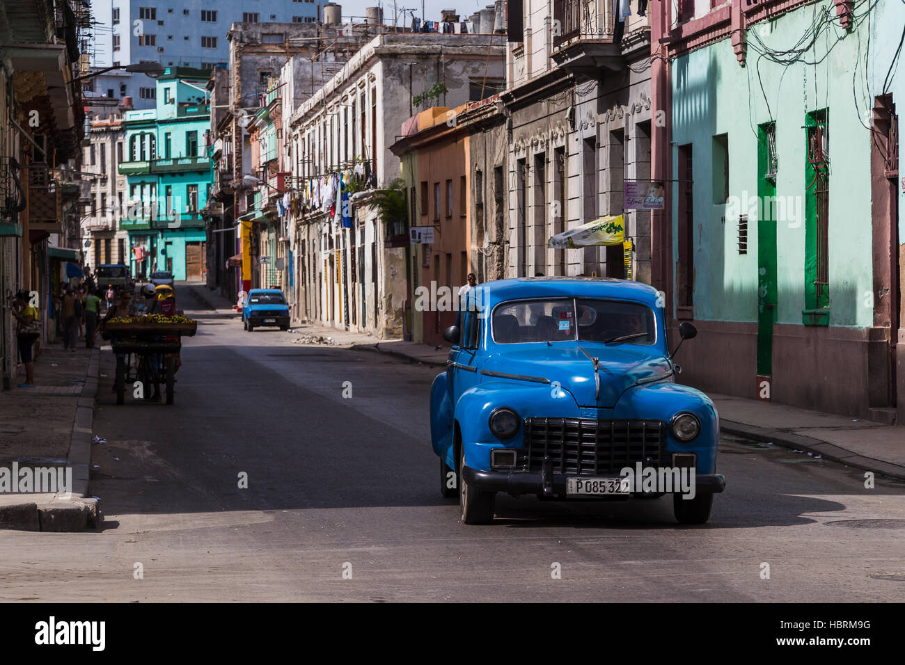 A blue classical estate from the 1950's navigates the streets of Centro Havana one morning in Cuba. Stock Photo