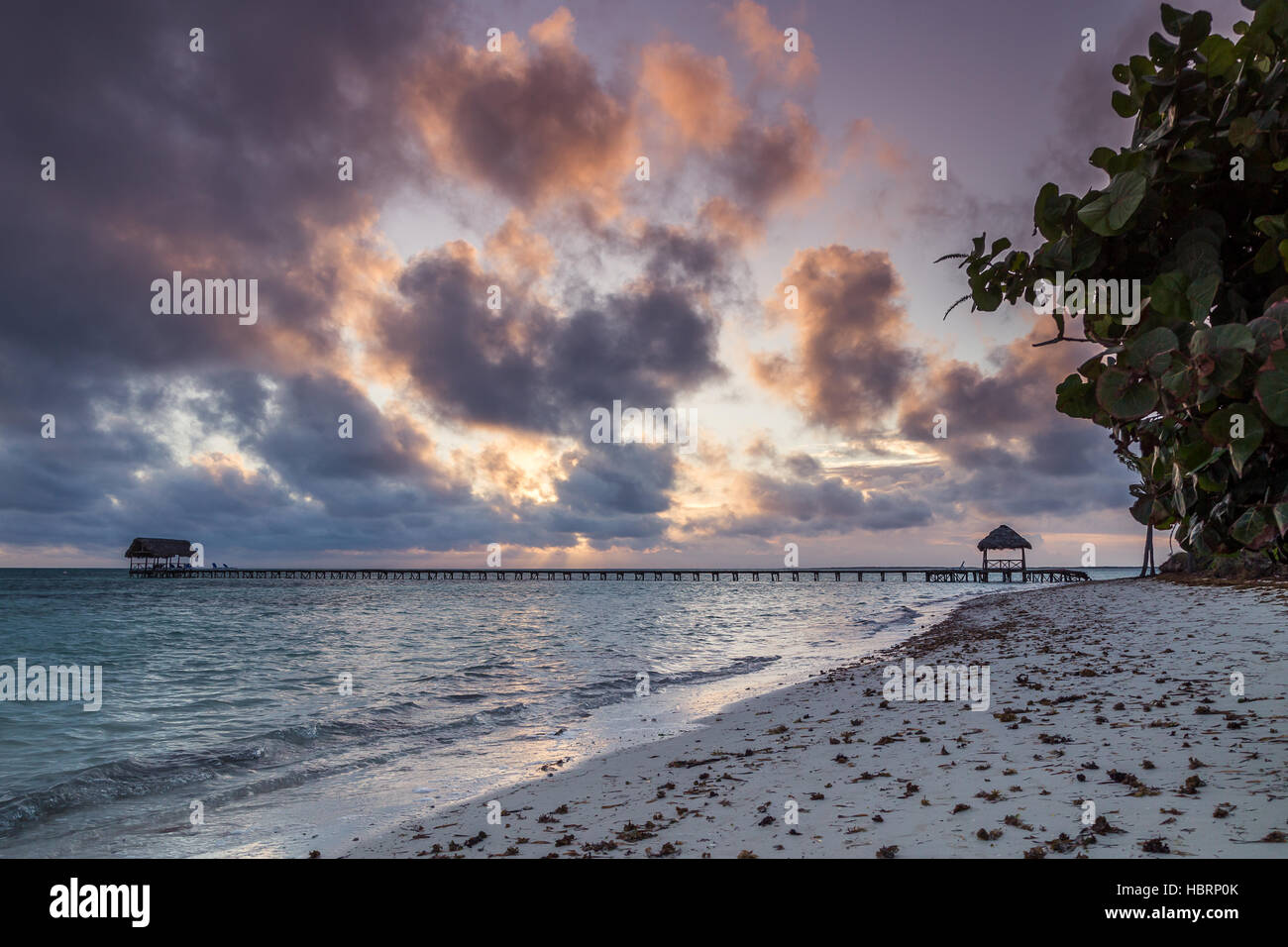 Clouds obscure the sun as it rises over the white sandy beach of Cayo Guillermo in Cuba early one morning. Stock Photo