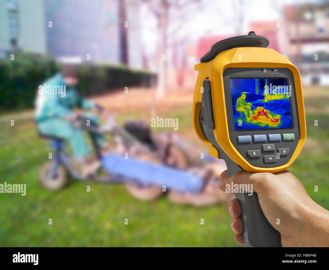 Recording with Thermal camera workers cutting grass in city park Stock Photo