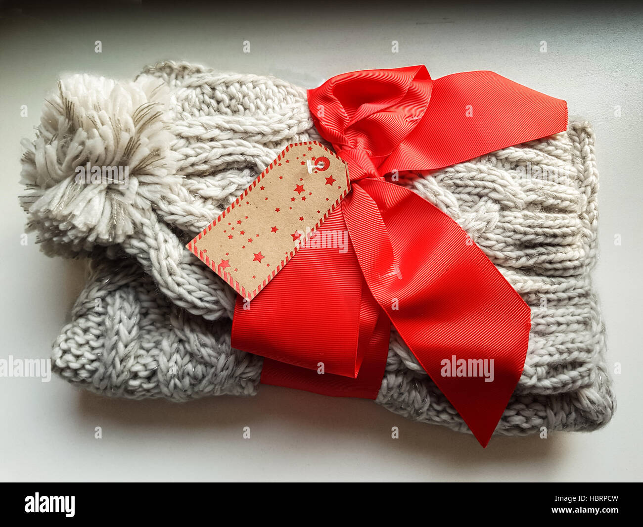 View at present winter hat and scarf with a red ribbon Stock Photo