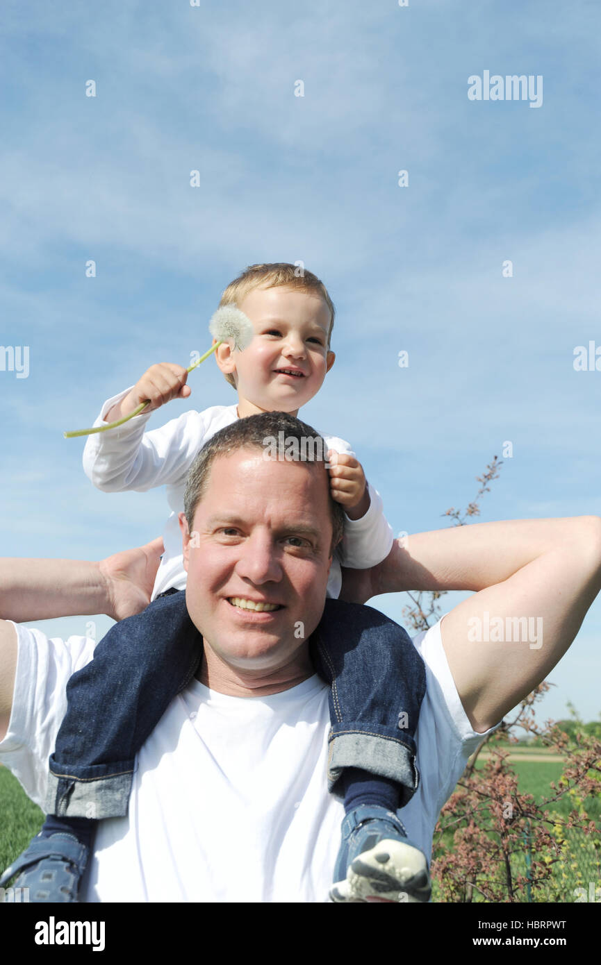 father is carrying his son on his shoulders Stock Photo