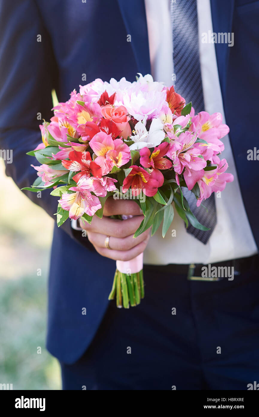 groom holds the brides bouquet in wedding day Stock Photo Alamy