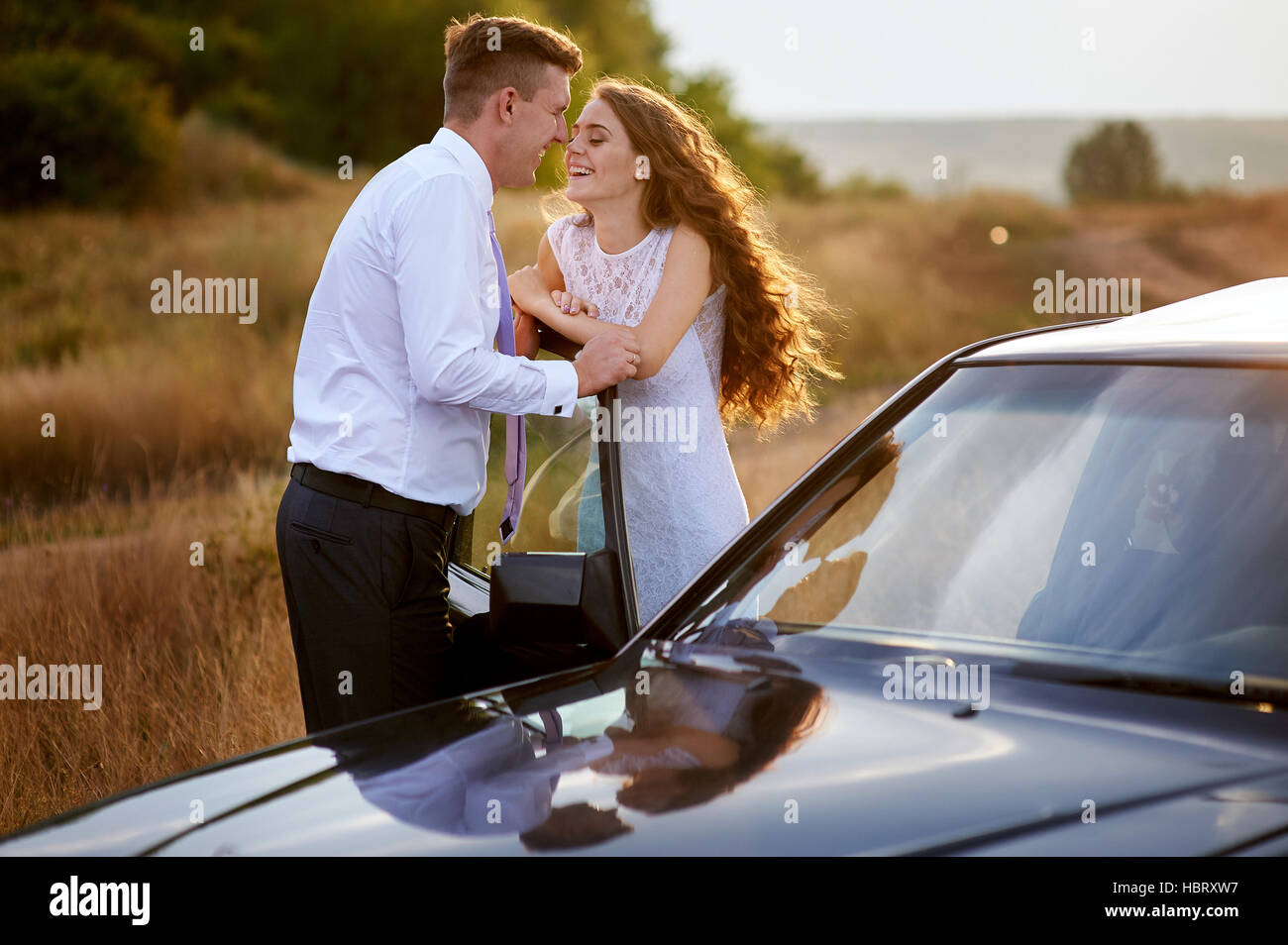 bride and groom kissing near car on wedding walk Stock Photo - Alamy