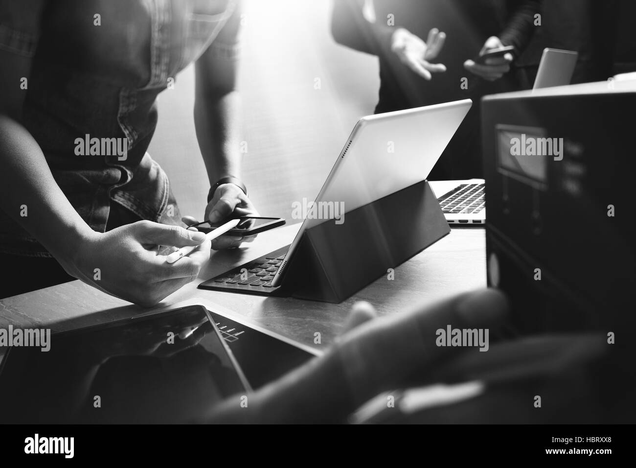 StartUp Programming Team. Website designer working digital tablet dock keyboard and computer laptop with smart phone and compact server on mable desk, Stock Photo