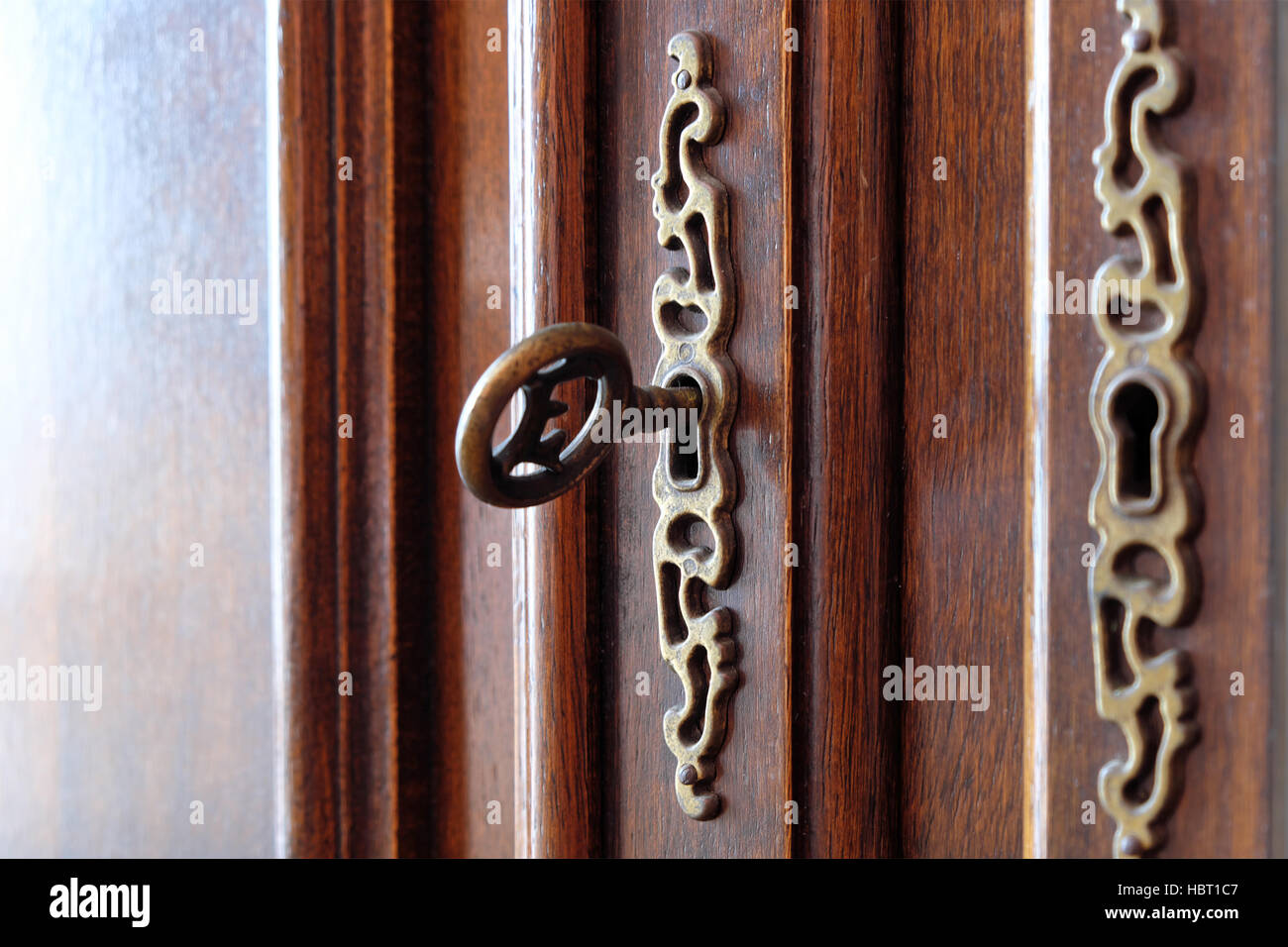 vintage key in beautiful wooden door / furniture Stock Photo