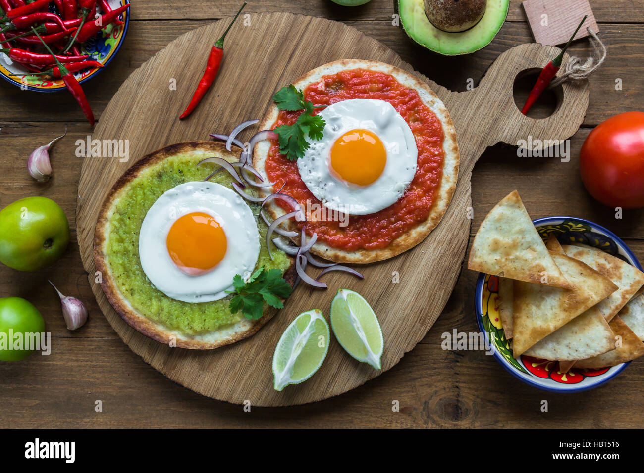 huevos divorciados, fried eggs on corn tortillas with salsa verde and  roja, mexican breakfast Stock Photo