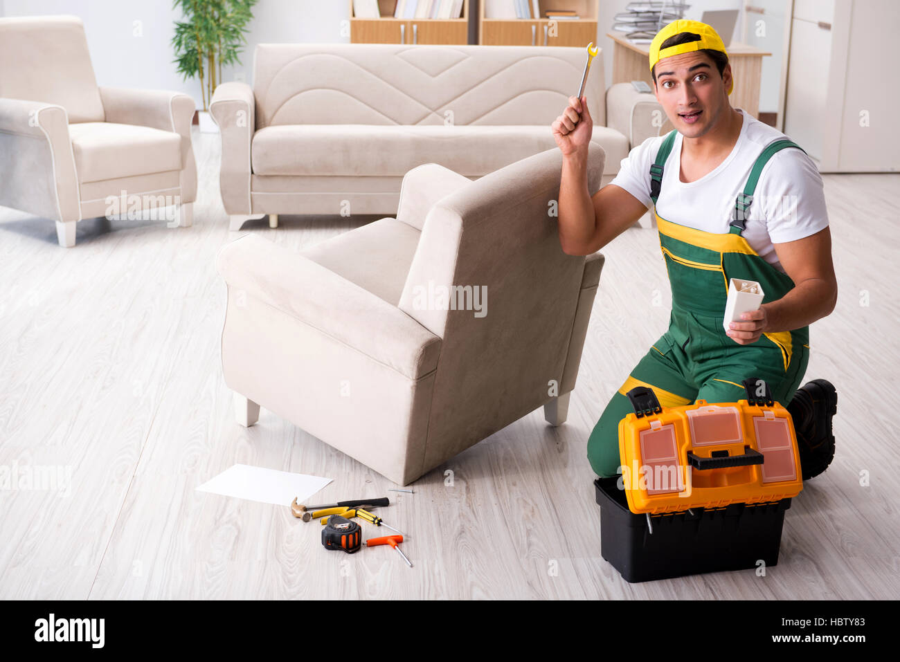 Furniture repairman repairing armchair at home Stock Photo Alamy