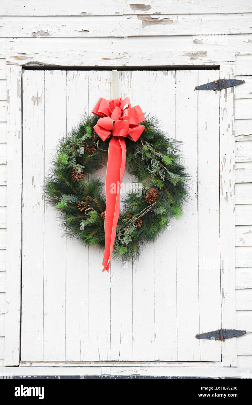 A Christmas wreath made of pine branches on a barn loft door, USA Stock Photo