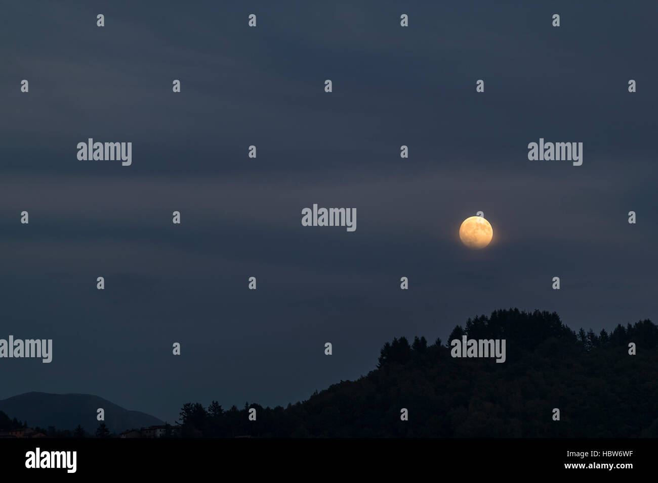 Moon rising over the medieval hilltop town of Barga, in Tuscany, Italy. Stock Photo