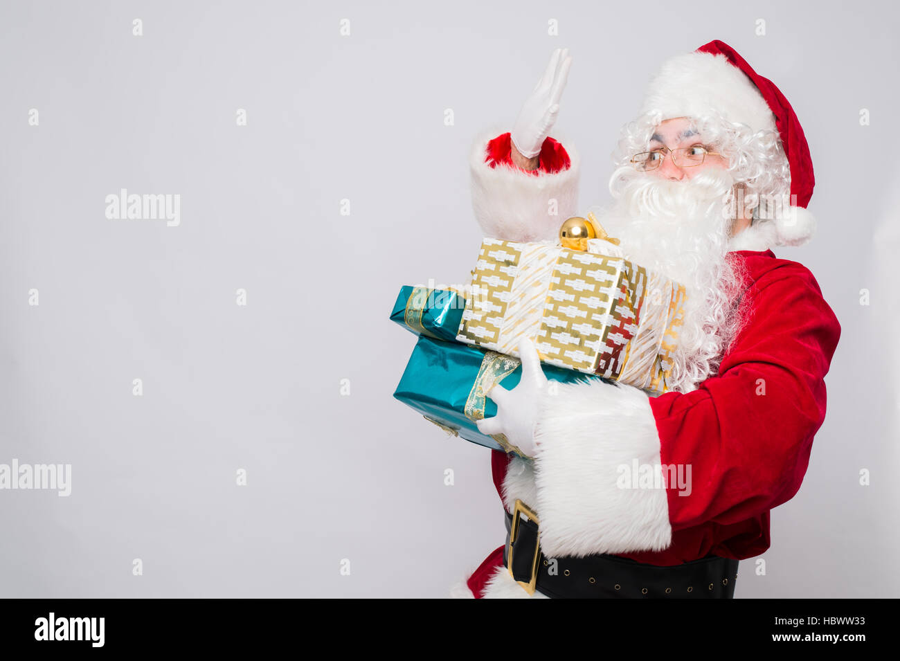 Portrait of Cheerful Santa Claus holding Christmas presents against ...
