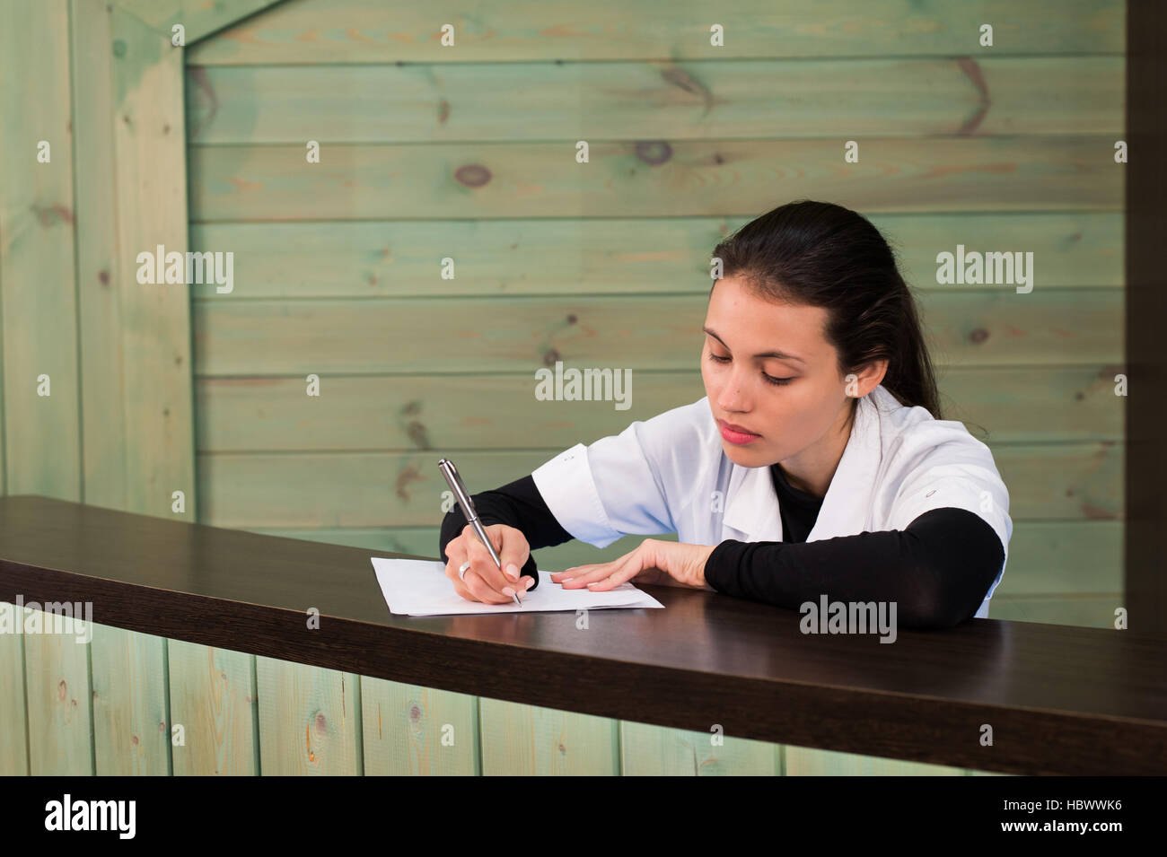 The female doctor sits at a table having closed eyes for fatigue Stock Photo