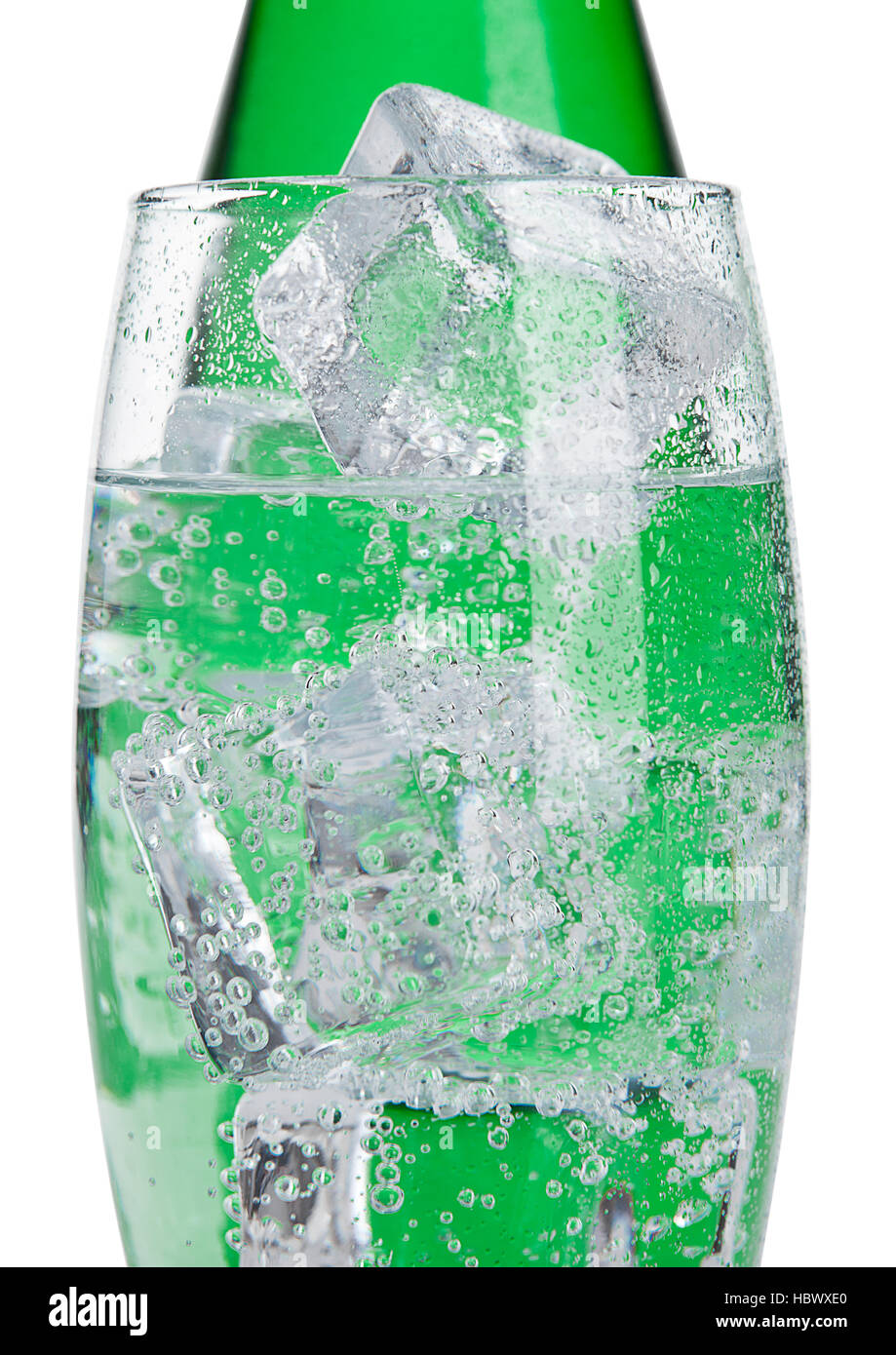 Bottle and glass with healthy sparkling water with ice cubes on white ...