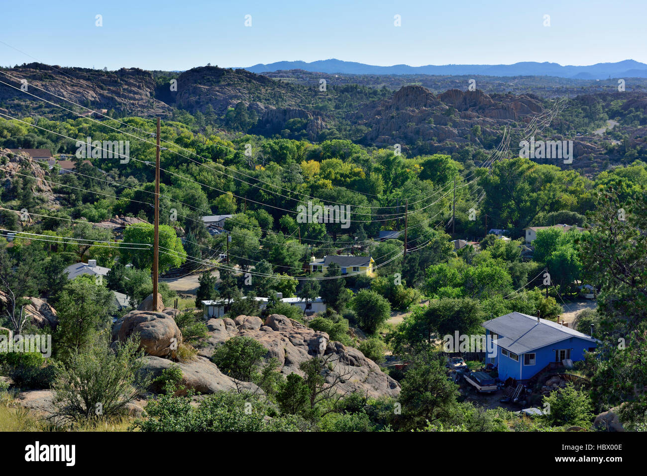 Rugged rocky terrain with houses and electric power lines extending into distance, Granite Dells, Prescott, Arizona Stock Photo