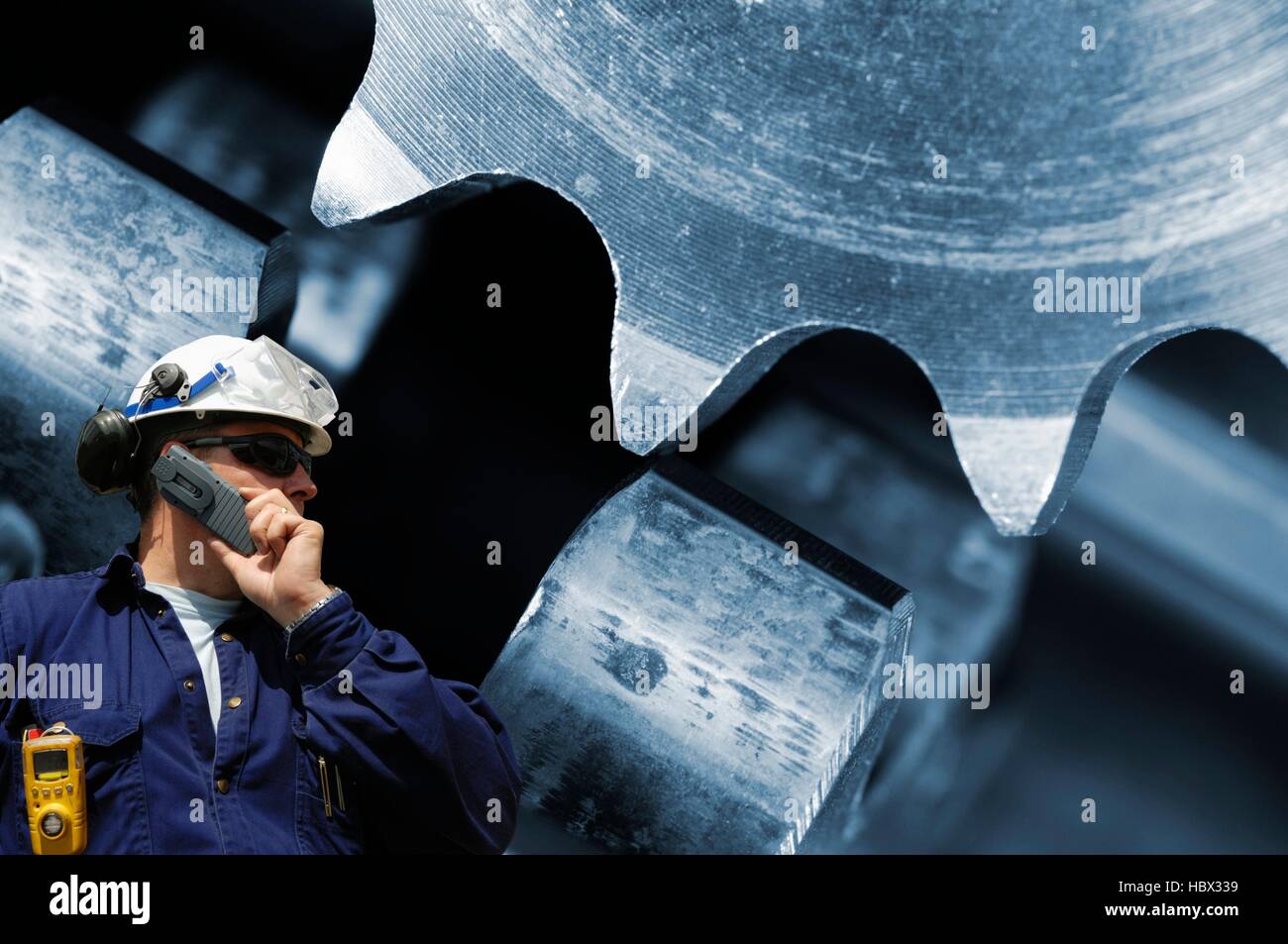 MODEL RELEASED. Engineer with gears and cogs Stock Photo - Alamy