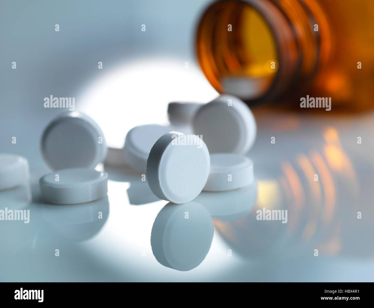 Pain killers pouring from a medicine bottle Stock Photo