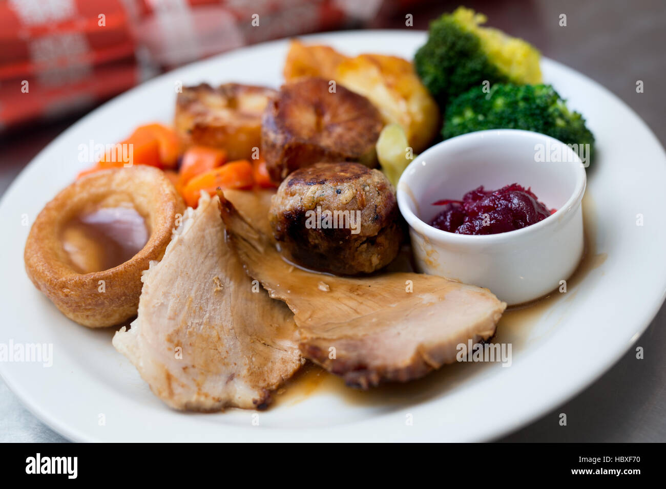 Roast dinner with christmas cracker in the background to reflect a christmas dinner Stock Photo