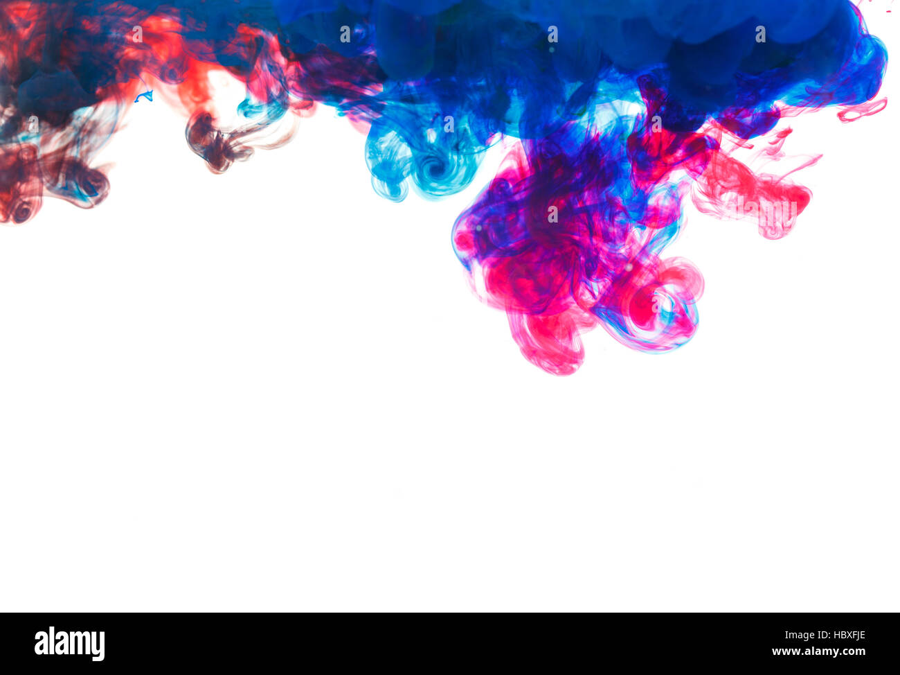 Color drop underwater creating a silk drapery. Ink swirling underwater. Cloud of colorful ink Stock Photo