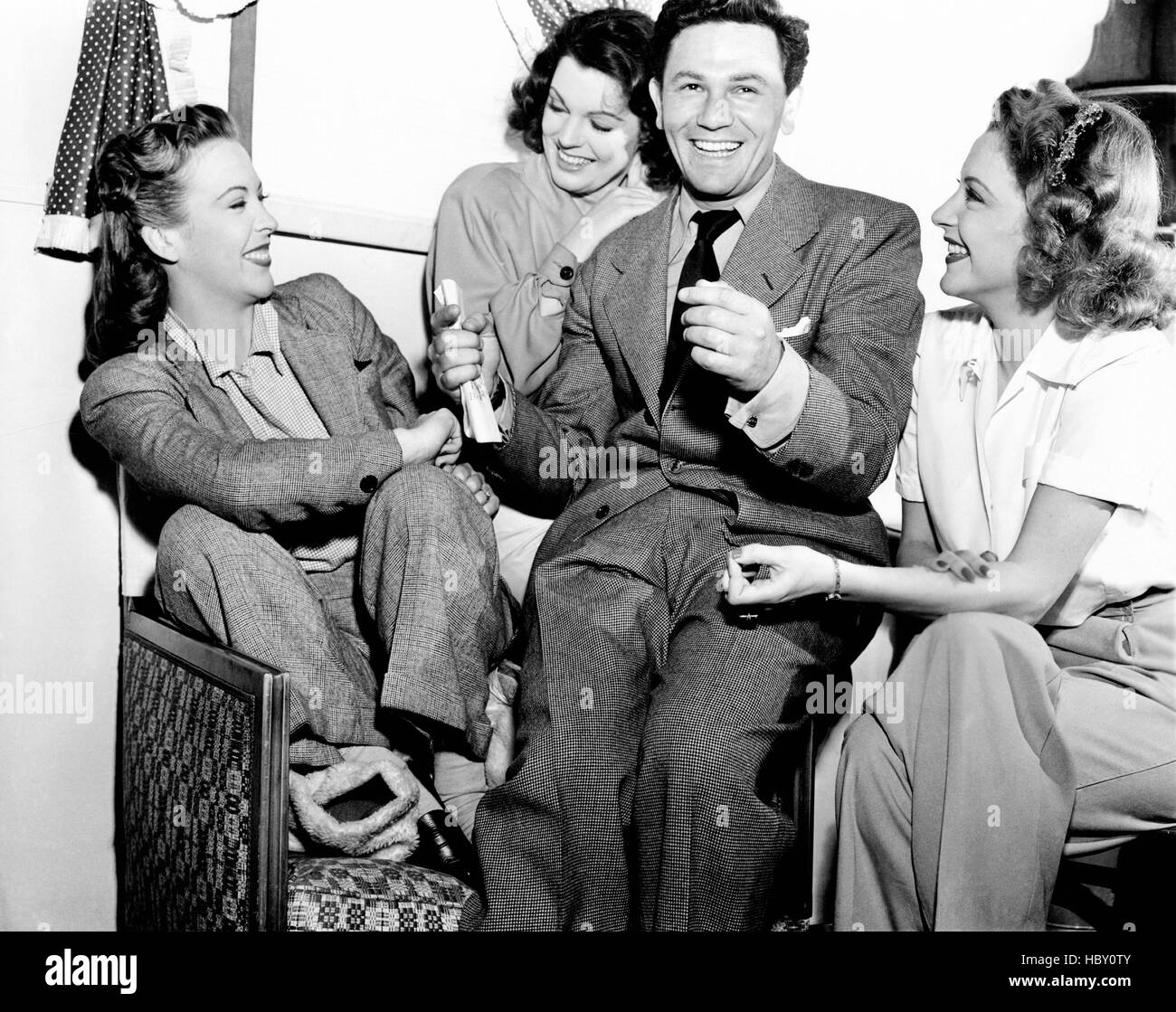 HOLLYWOOD CANTEEN, from left, Andrea King, Lynn Baggett, John Garfield, Julie Bishop, having a laugh between takes, 1944 Stock Photo