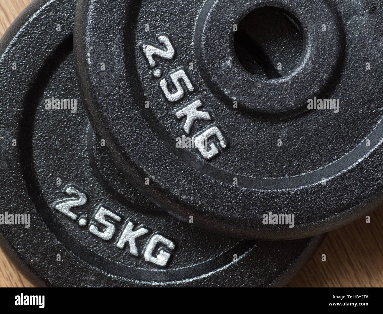 Two 2.5kg weight plates of barbell piled on the floor Stock Photo