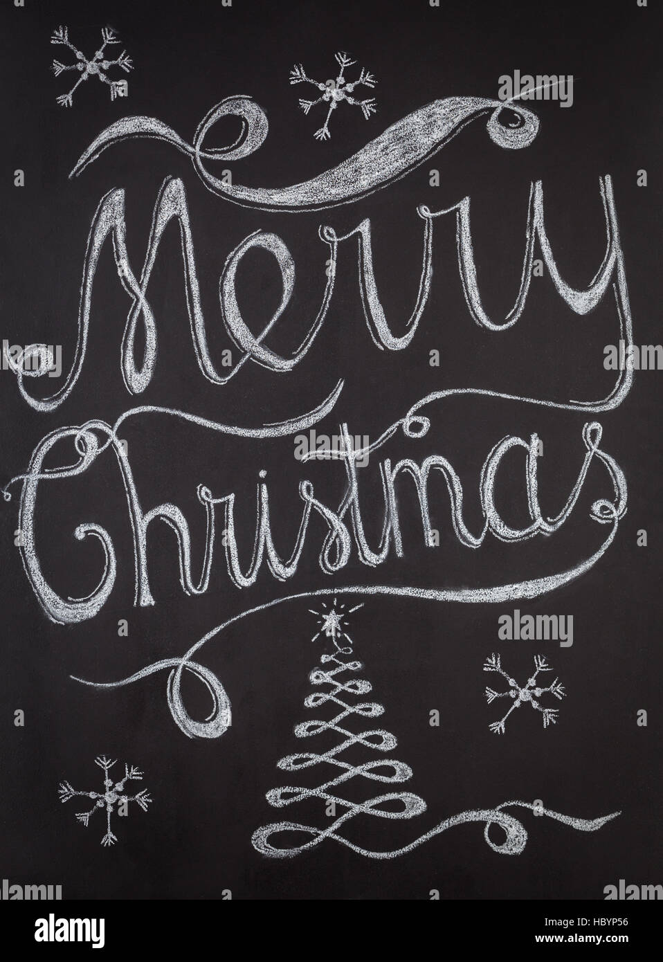 Merry Christmas hand drawn lettering with chalk on blackboard. Elegant unique design with snowflakes and Christmas tree Stock Photo