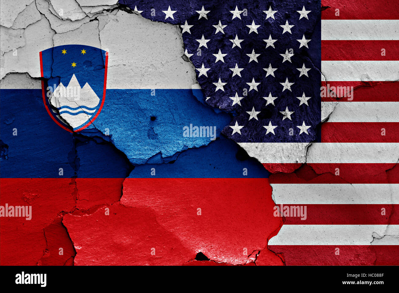 flags of Slovenia and USA painted on cracked wall Stock Photo