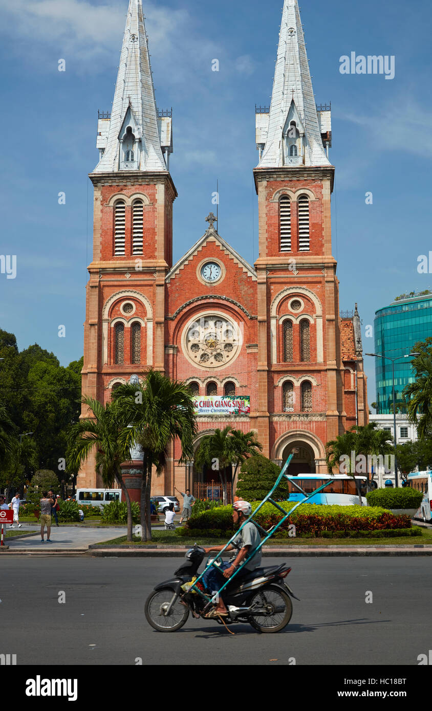 Motorcyclist carrying ladder and Notre-Dame Cathedral Basilica of Saigon, Ho Chi Minh City (Saigon), Vietnam Stock Photo