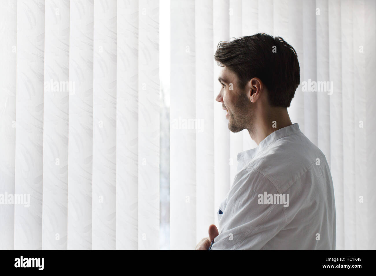 Man stands in a half turn and smiling Stock Photo