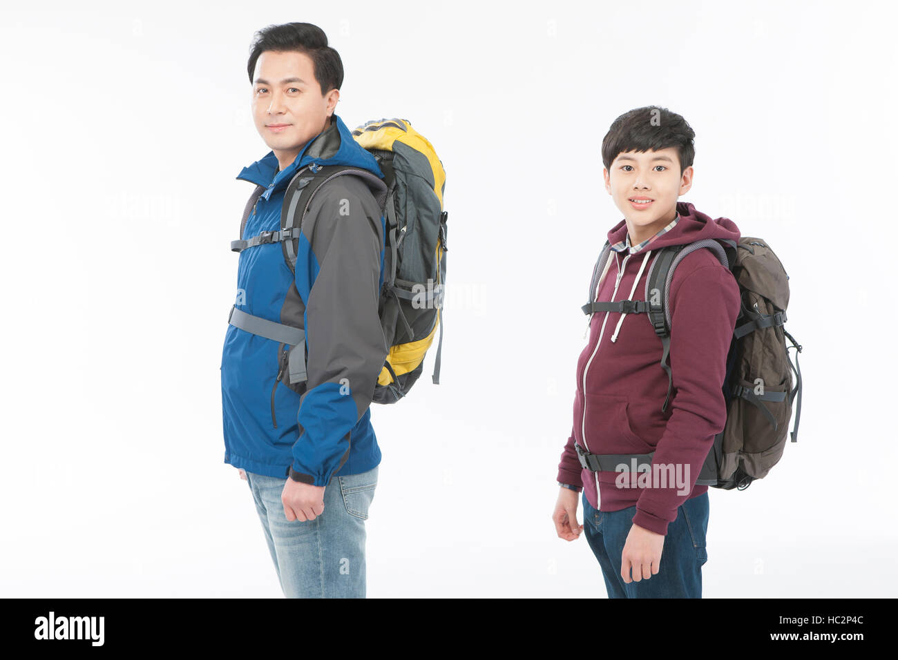 Side view of smiling father and son with backpacks Stock Photo