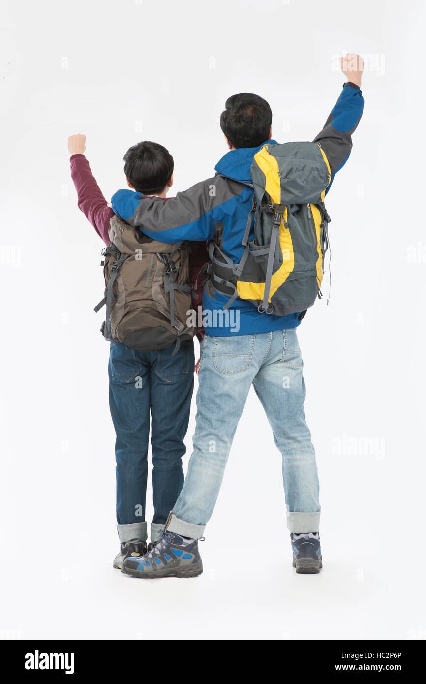 Back of father and son with backpacks standing cheering Stock Photo