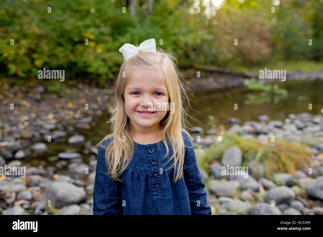 Young girl posing for a lifestyle portrait along the banks of the McKenzie River in Oregon. Stock Photo