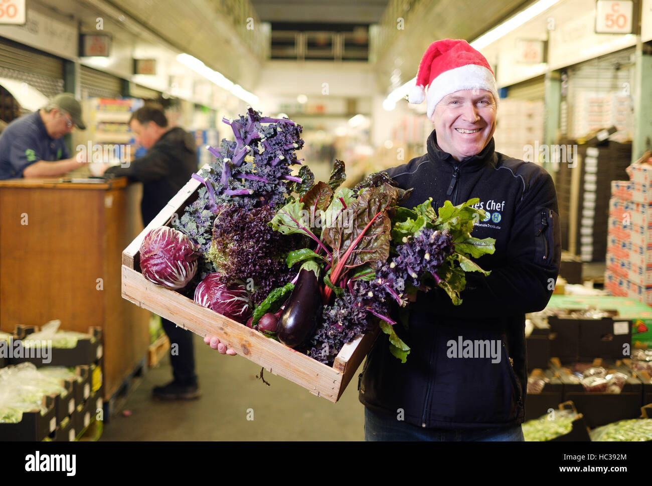EDITORIAL USE ONLY Trader Craig Currie from Yes Chef, prepares a box of purple seasonal vegetables ahead of Christmas at New Covent Garden Market, in Nine Elms, London. Stock Photo