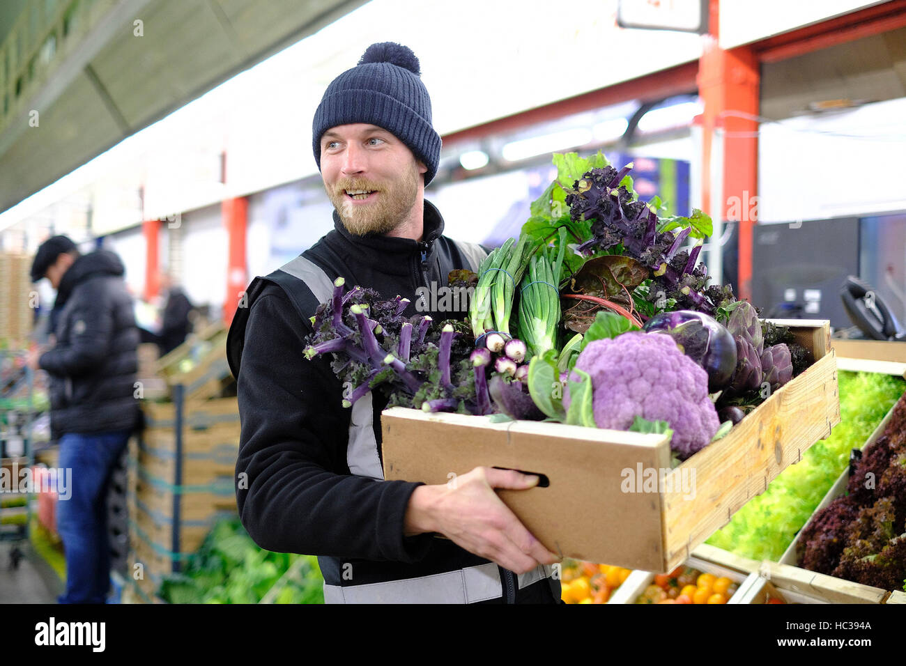 EDITORIAL USE ONLY Trader Ben Perry from French Garden, prepares a box of purple seasonal vegetables ahead of Christmas at New Covent Garden Market, in Nine Elms, London. Stock Photo