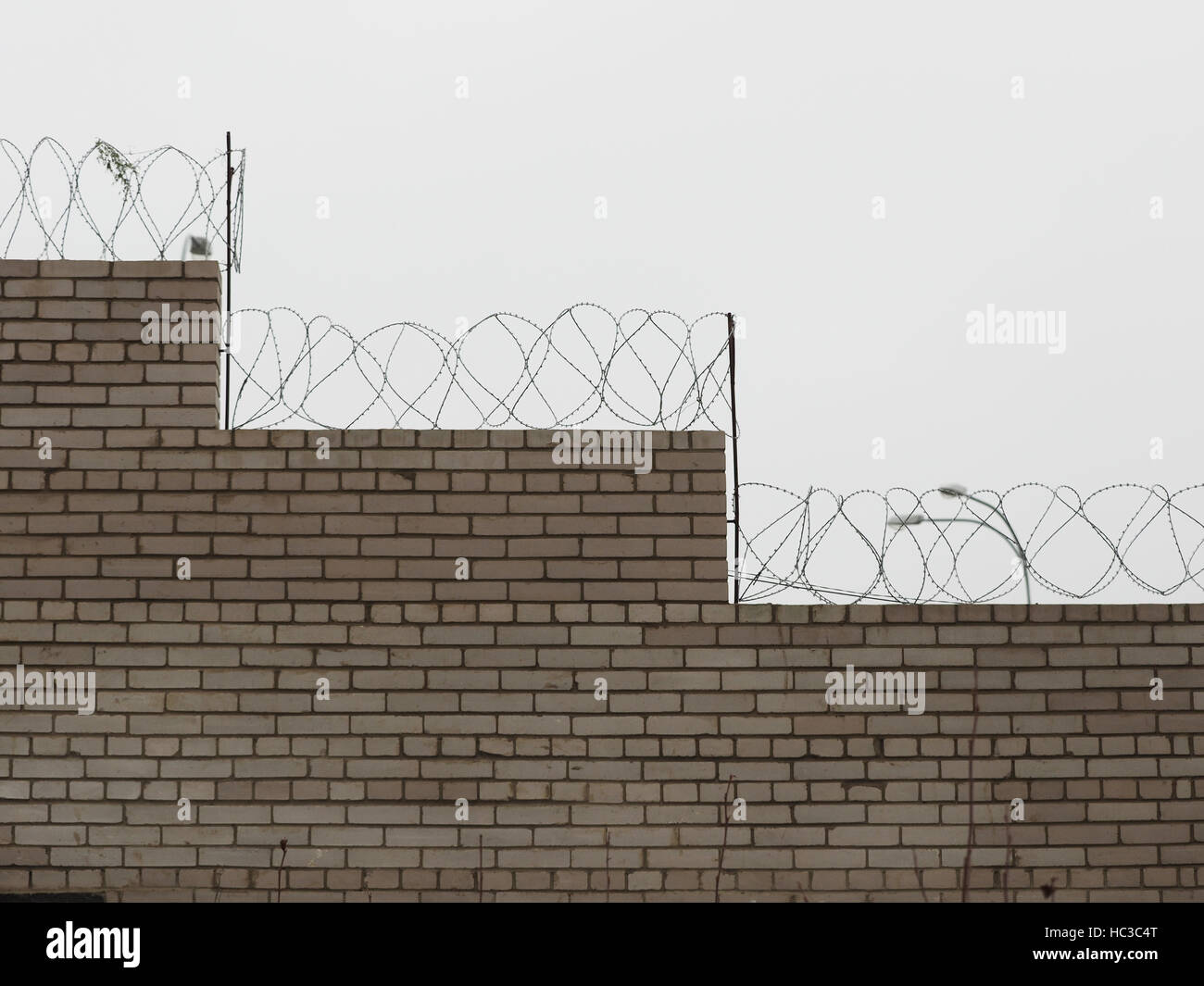 brick fence with barbed wire Stock Photo - Alamy