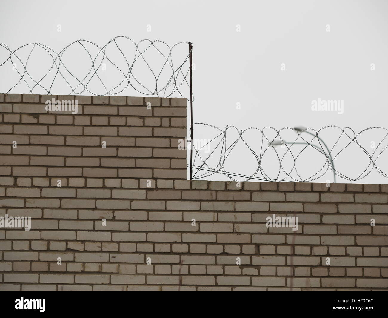 brick fence with barbed wire Stock Photo - Alamy