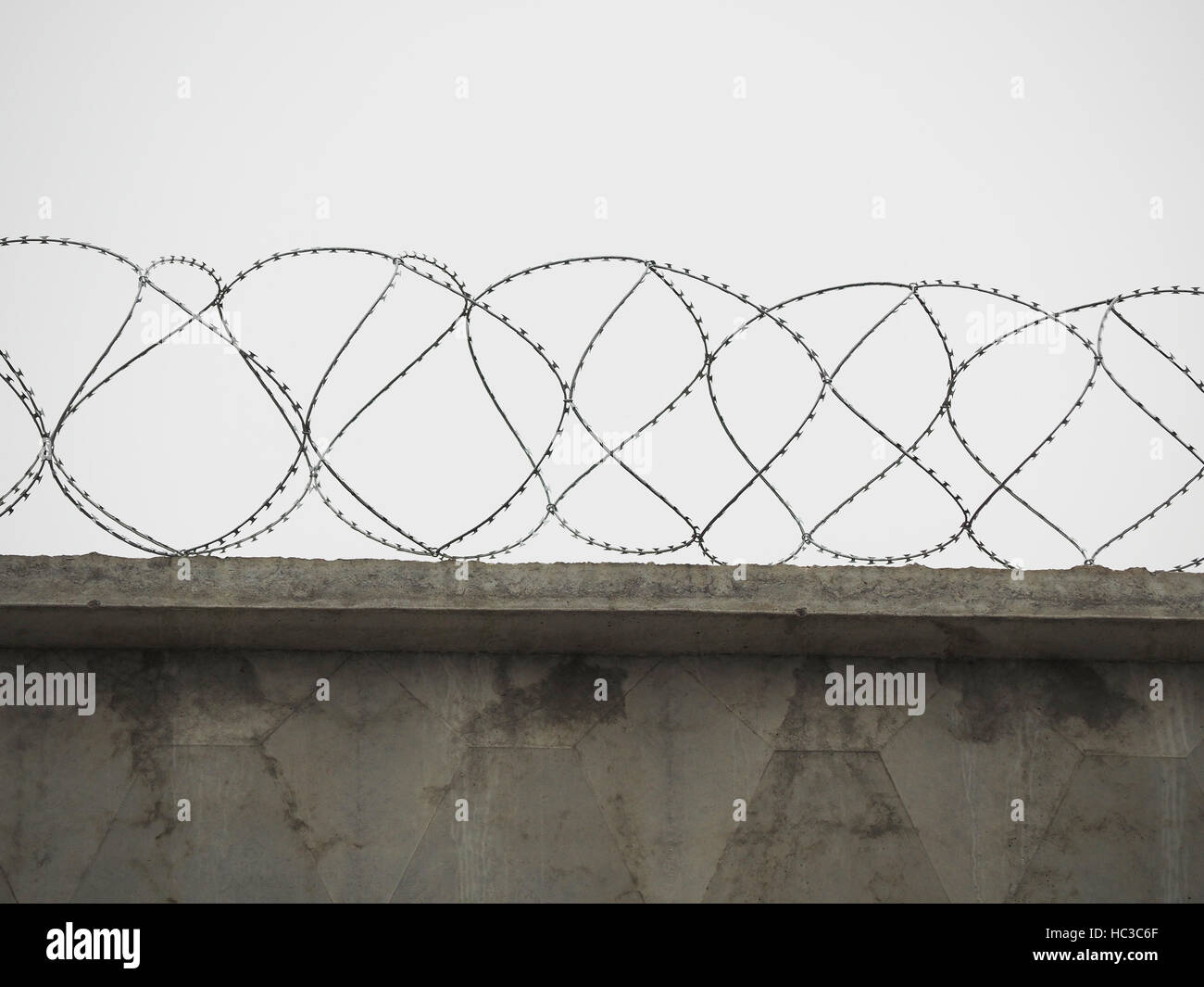 brick fence with barbed wire Stock Photo - Alamy