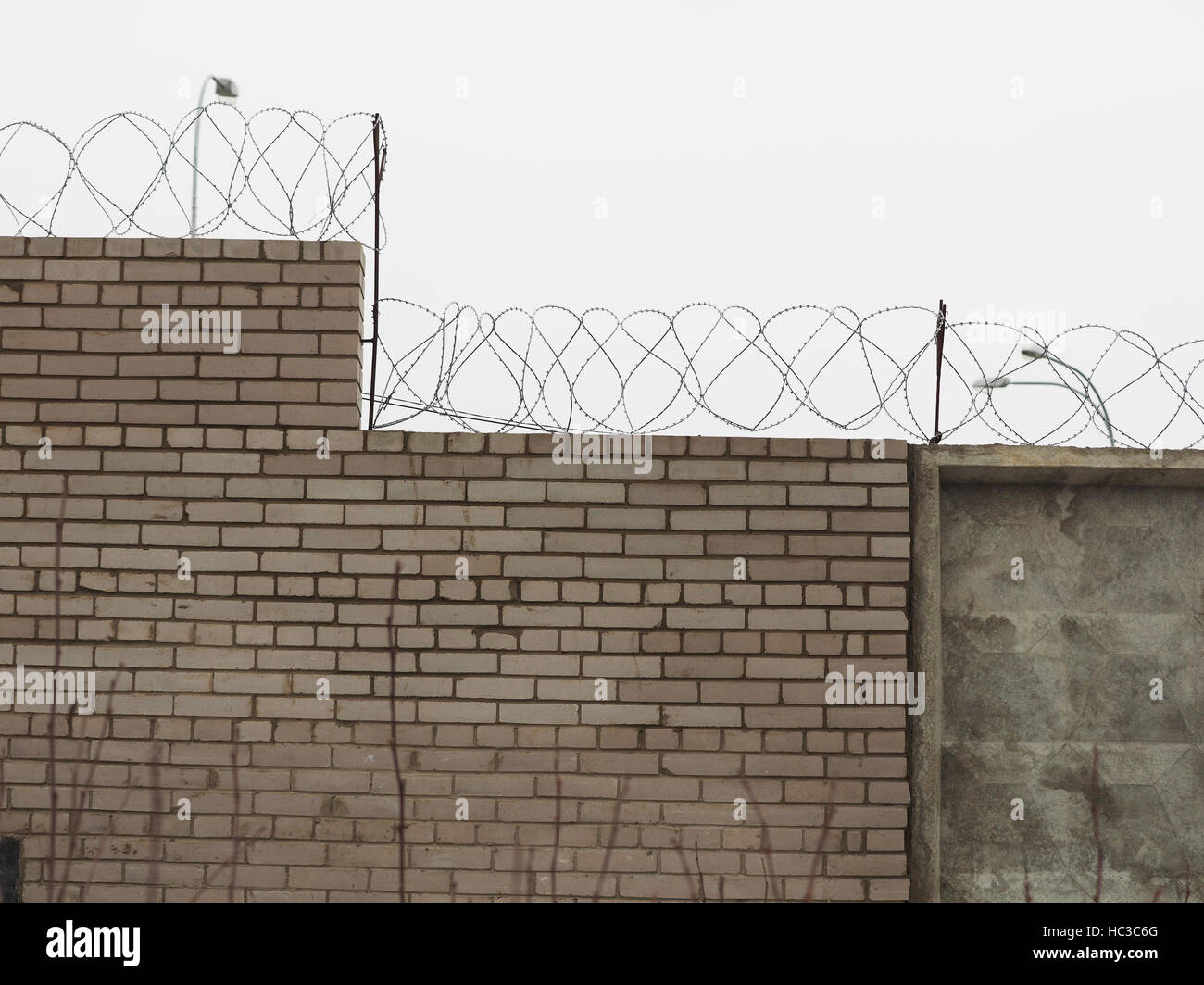 brick fence with barbed wire Stock Photo - Alamy