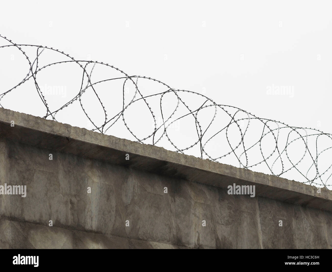brick fence with barbed wire Stock Photo - Alamy