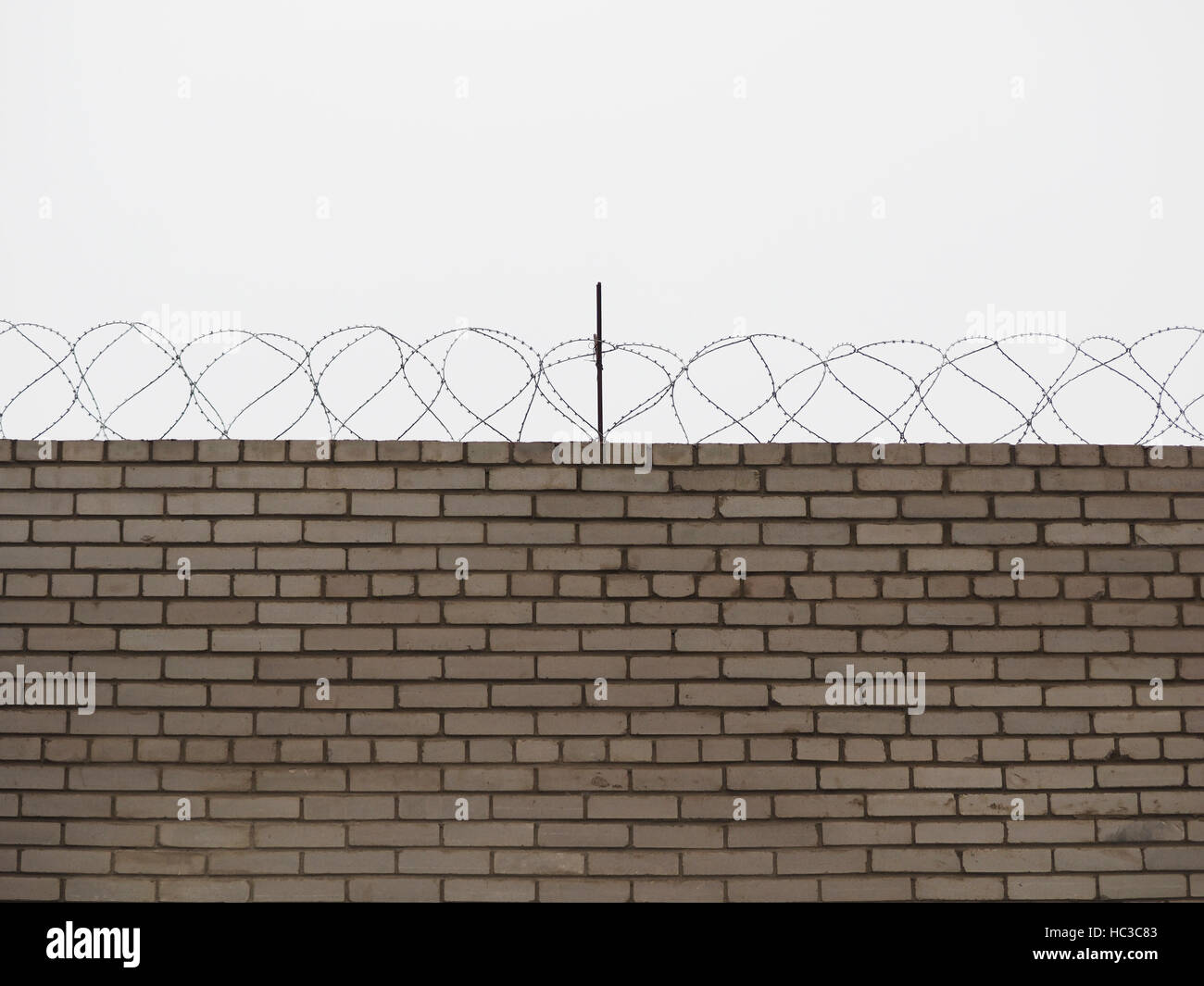 brick fence with barbed wire Stock Photo - Alamy