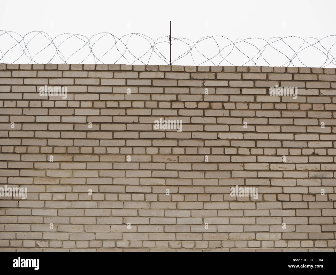 brick fence with barbed wire Stock Photo - Alamy