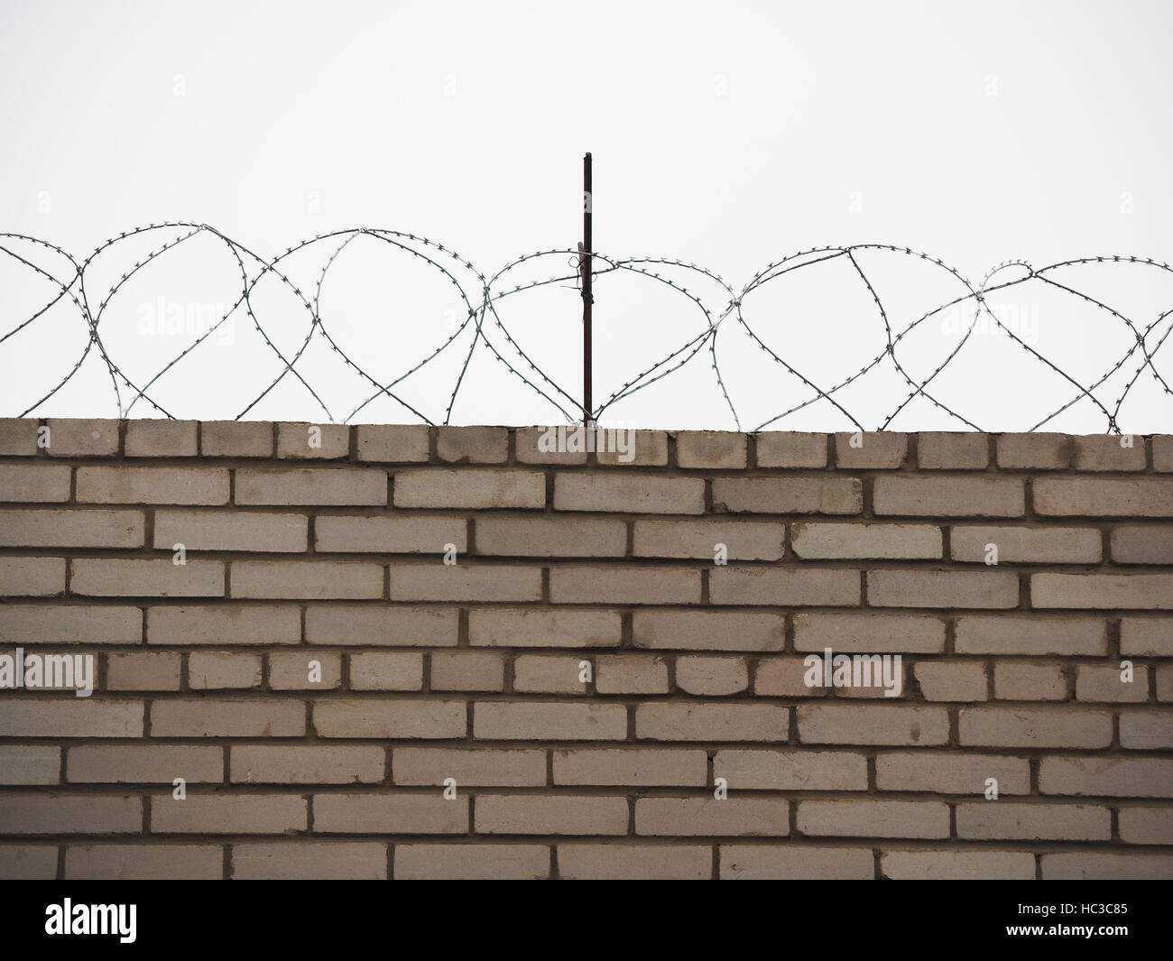 brick fence with barbed wire Stock Photo - Alamy