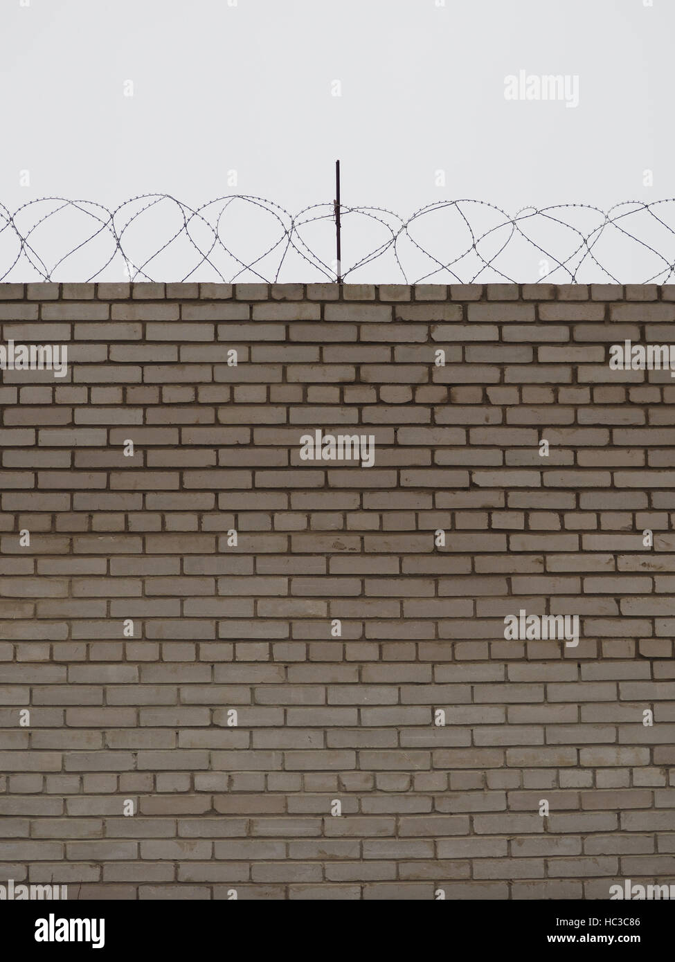 brick fence with barbed wire Stock Photo - Alamy
