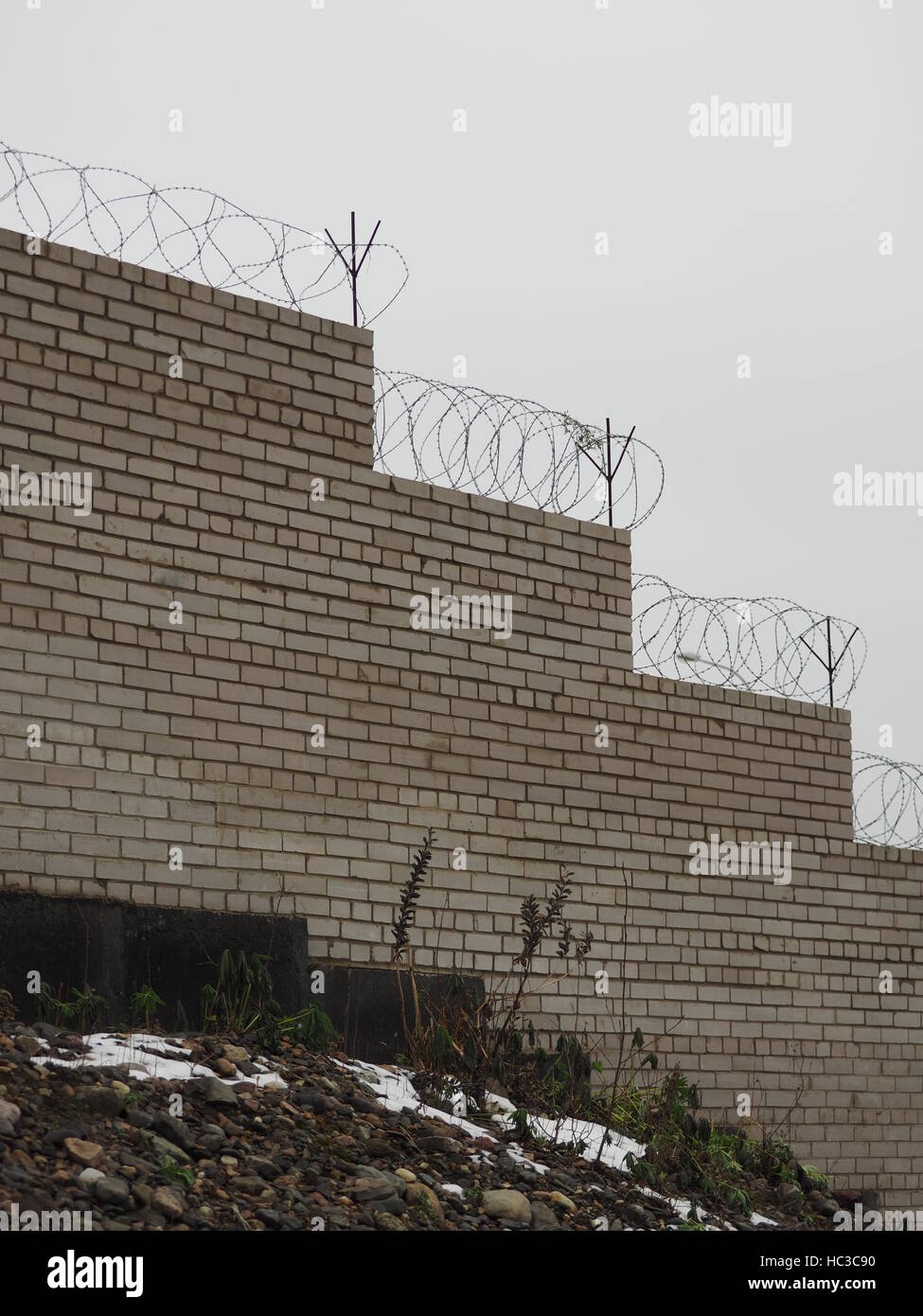 brick fence with barbed wire Stock Photo - Alamy